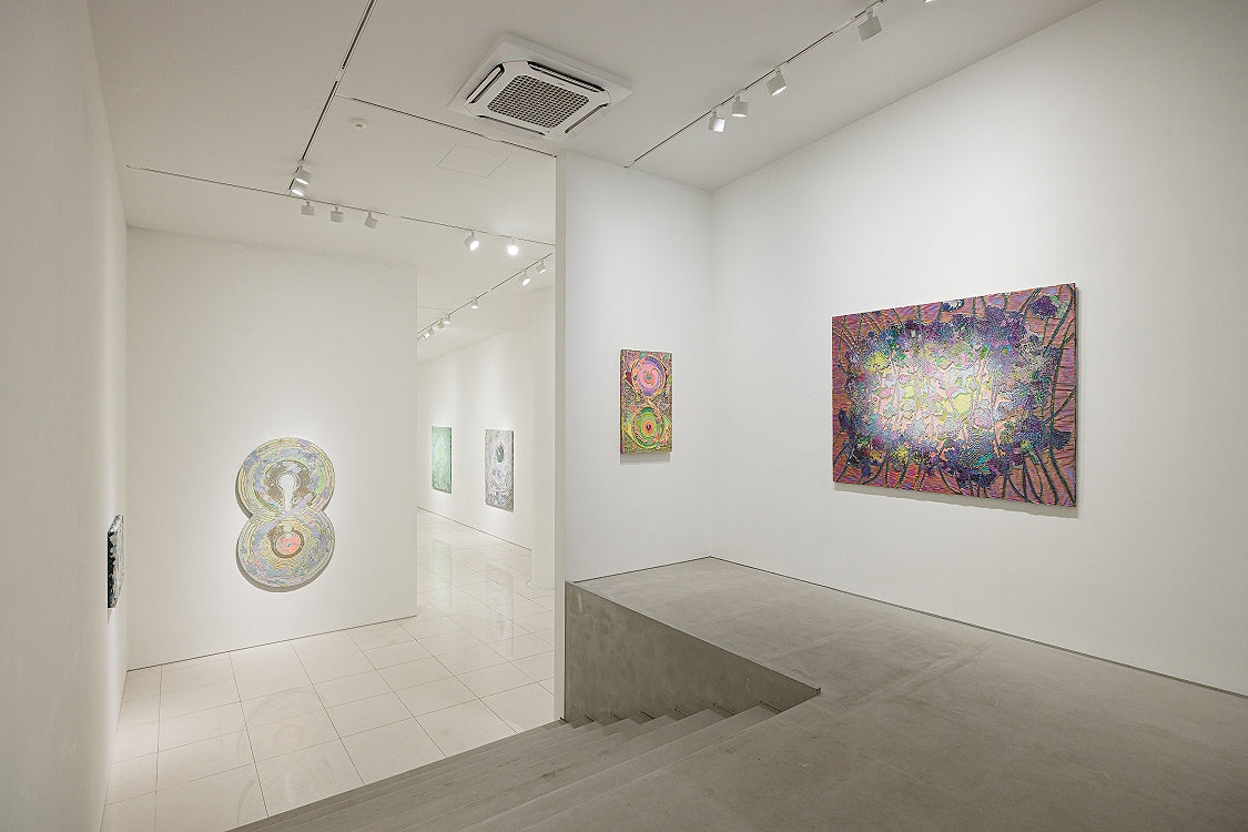 ภาพห้องจัดแสดงนิทรรศการ Spiral of Energy ที่ Whitestone Gallery กรุงโซล มีผลงานหลายชิ้นแขวนบนผนังขาว
