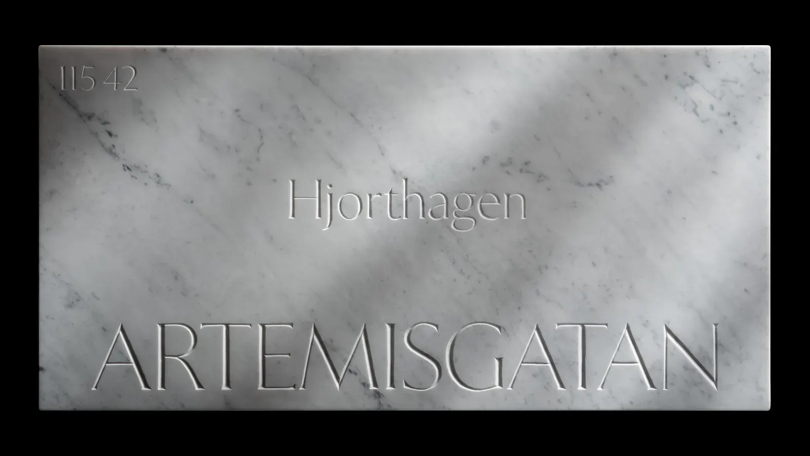 ป้ายชื่อถนนหินอ่อนที่สลักด้วยฟอนต์ Exemplar ของ Letters from Sweden