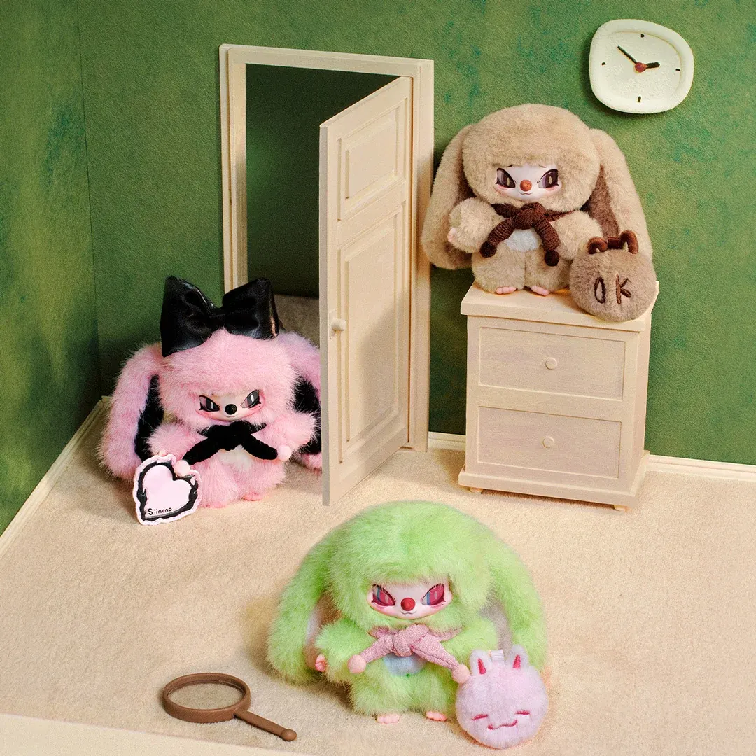 ตุ๊กตาสีชมพู เขียว และน้ำตาลในฉากห้องจิ๋วผนังสีเขียว