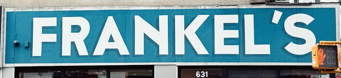 ป้ายร้าน FRANKEL S ตัวอักษรขาวบนพื้นฟ้า