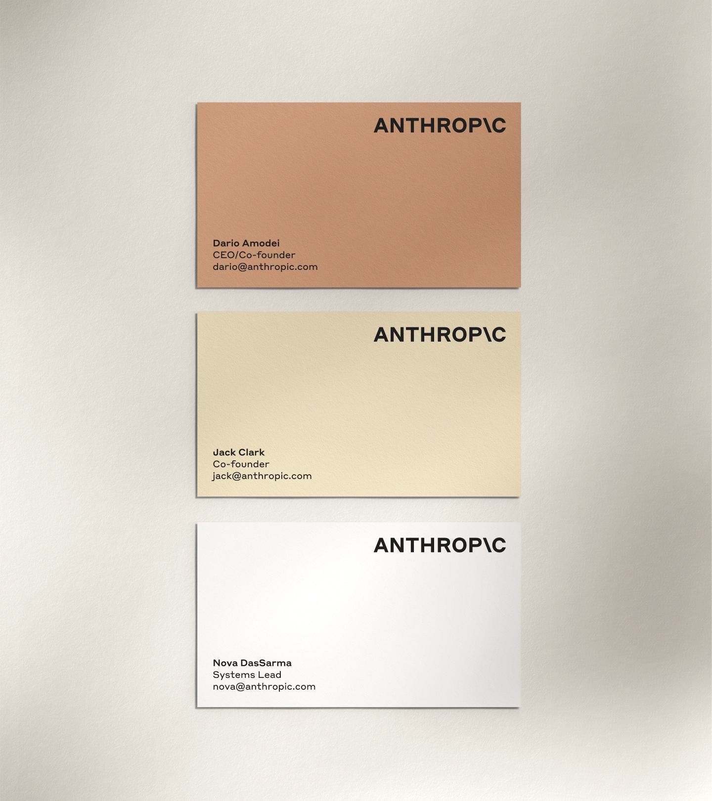 นามบัตร Anthropic สามใบ สีส้มอิฐ สีครีม และสีขาว