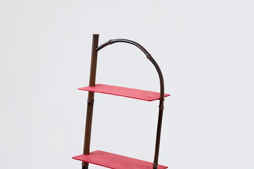 ชั้นวางของไม้ไผ่สีแดงชื่อ n shelf พิงผนังในห้อง