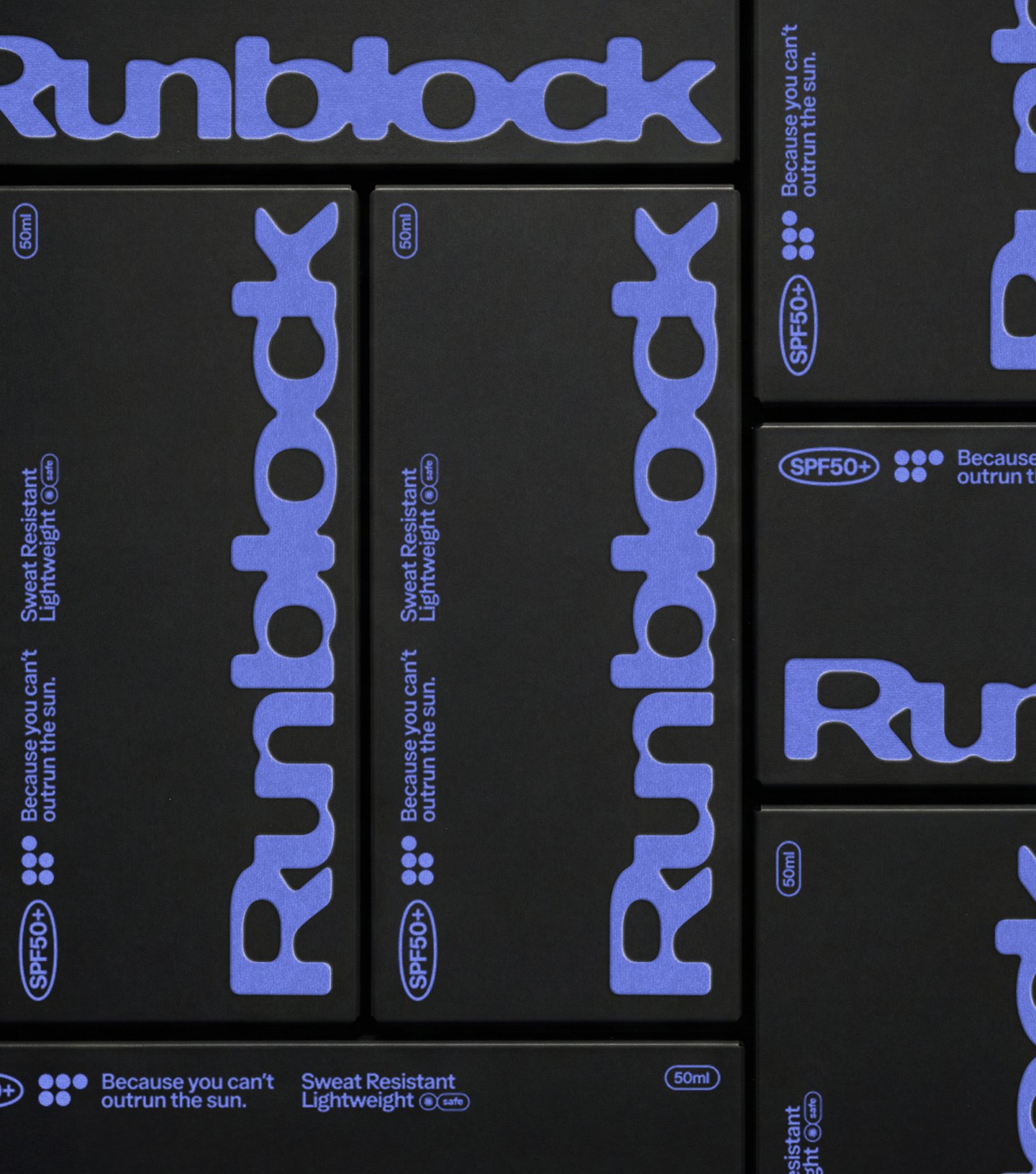 กล่องกระดาษสีดำของ Runblock วางเรียงกัน พิมพ์โลโก้สีน้ำเงินม่วงในหลายทิศทาง