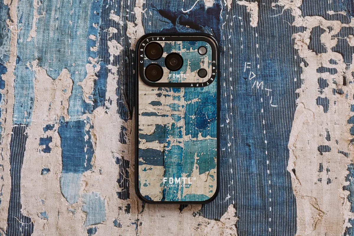 เคสโทรศัพท์ลายผ้าครามซีดวางบนผ้าโบโระของจริง