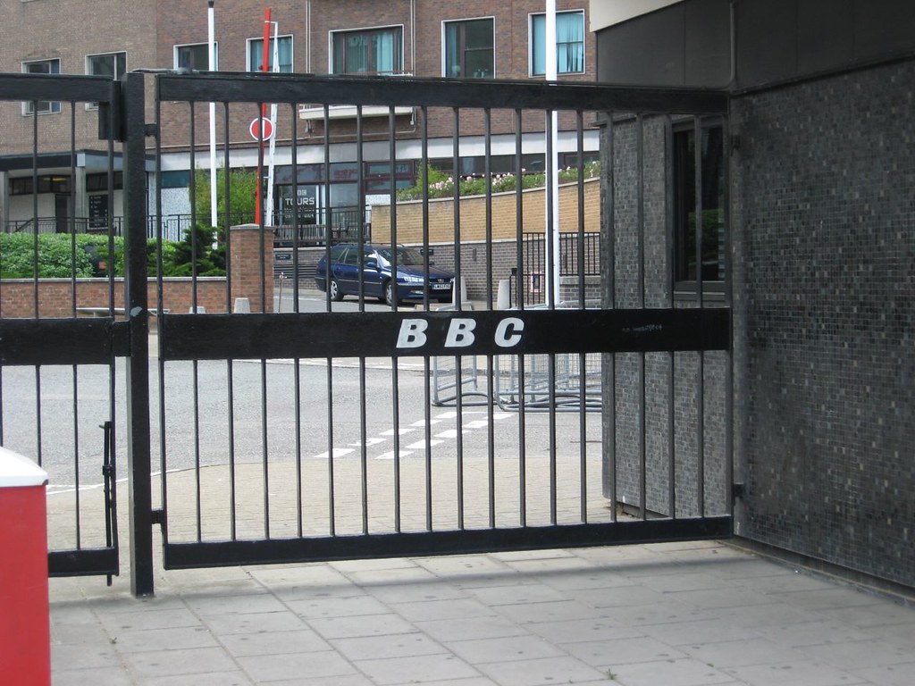 ตัวอักษร BBC สีขาวบนแถบเหล็กของประตูรั้วอาคาร Television Centre ในลอนดอน