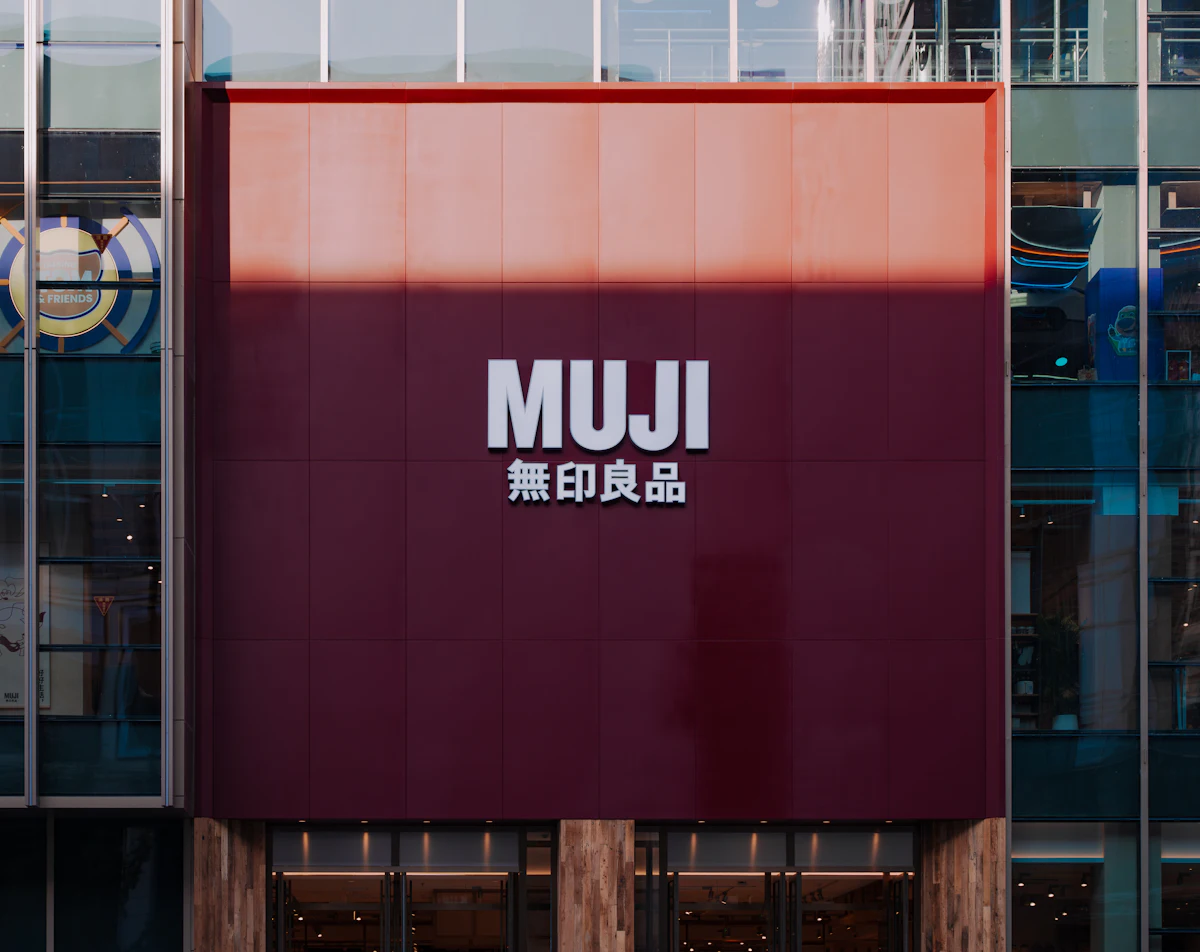 หน้าร้าน MUJI กับป้ายสีแดง แบรนด์ที่ชื่อแปลว่าไม่มียี่ห้อ