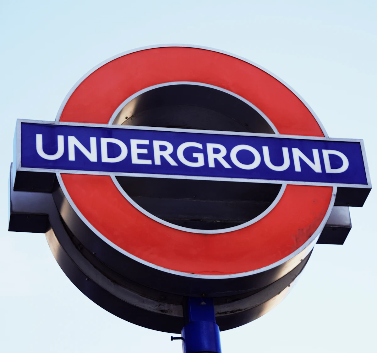ป้าย Underground สีน้ำเงินและแดงที่ใช้ตัวอักษร Johnston
