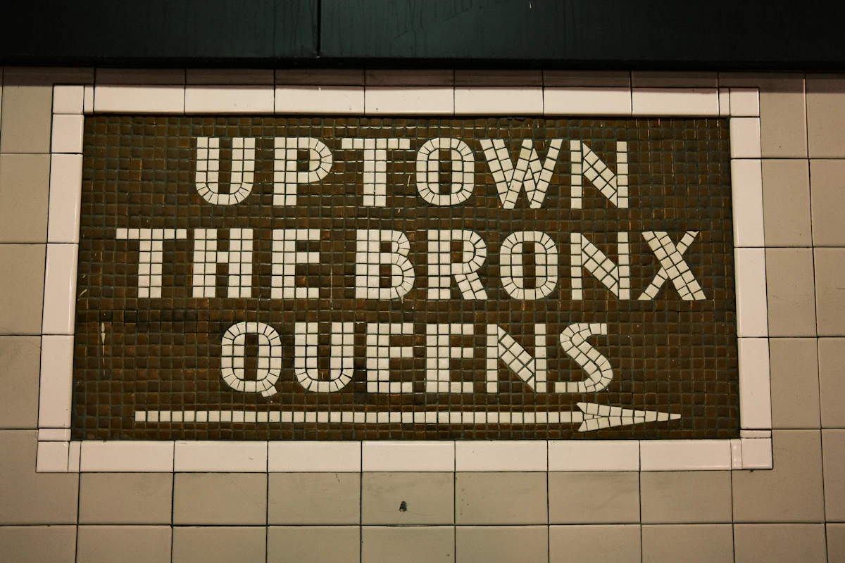 ป้ายบอกทิศทางในรถไฟใต้ดินนิวยอร์กระบุปลายทาง Bronx และ Queens